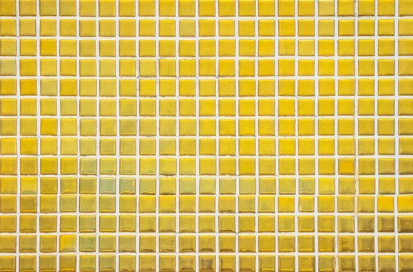 Gold yellow square mosaic tiles for ceramic wall and floor texture background in bathroom. Design golden pattern geometric with grid wallpaper decoration pool. Glass glitter seamless abstract surface.