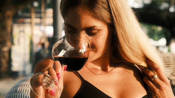 Lady drinking wine in a cafe in the evening