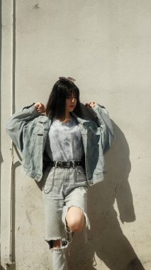 Evin duvarına karşı kameraya poz veren genç kız.