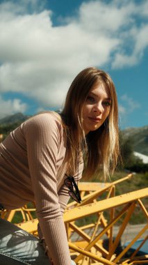 Mavi gökyüzüne karşı kameranın önünde poz veren manken kız