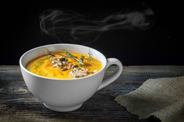 ahşap bir arka plan üzerinde kabak çekirdeği ile kabak çorbası