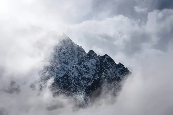 清晨被厚厚的云彩环绕的山峰和雪坡 — 图库照片
