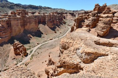 Kanyon, panoramik güneş ışığı manzaralı kayalar ve yollar.