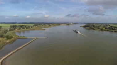 Hollanda 'nın güneyindeki Bergambacht köyü yakınlarındaki River Lek hava sahasında iç konteynır mavnası.
