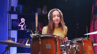 Müzik ve ritim. Kulaklık takan genç bir kadın özel odada elektronik müzik aleti çalıyor. Covid19 karantinası sırasında evde öz eğitim