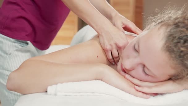 Vista de perto do massagista profissional fazendo relaxante massagem nas costas para senhora caucasiana. Conceito de procedimentos de beleza — Vídeo de Stock