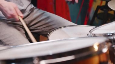 Garaj stüdyosunda davul çalmaktan zevk alan günlük kıyafetler giyen genç beyaz bir adam. Müzik konsepti
