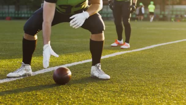 Involved at the game. Cropped view of the American football player throwing ball to his friend while training during the game. Sport concept — Stock Video