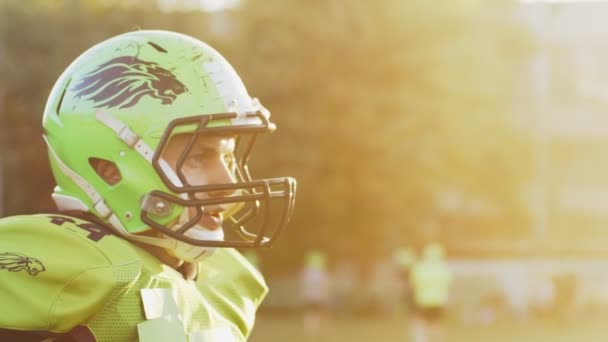 Closeup side portrait of American football player catching the ball while standing at the stadium during the game. Sport concept — Stock Video