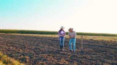 Erkek çiftçi, kadın meslektaşıyla tohum ekmeden önce toprağın kalitesini kontrol ediyor. Toprağı elinde tutan adam. Tarım uzmanı kız tahıl ekmenin kalitesini kontrol ediyor.