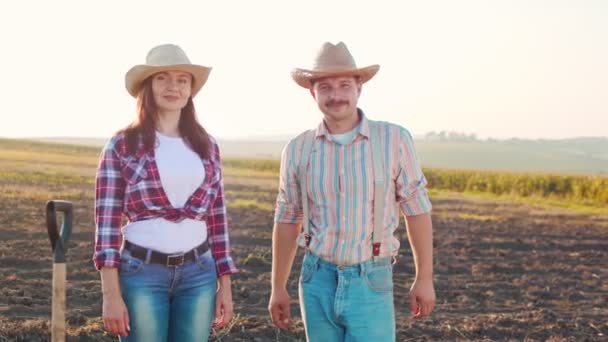 夏の間の仕事を楽しみながら、シャベルを持ち、よく見ている男性と女性の農家の完全な長さ。農業事業の概念 — ストック動画