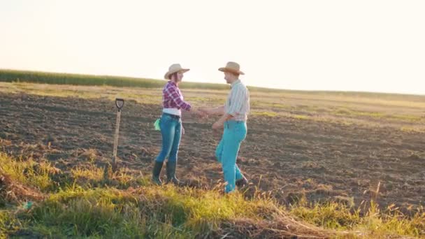 Retrato de adultos positivos agricultores masculinos e femininos indo um para o outro e cumprimentando no campo enquanto sorri. Conceito de jardineiro, agronomia e agricultura — Vídeo de Stock