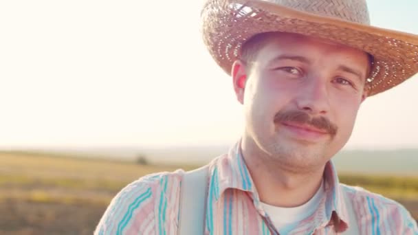 Hombres adultos caucásicos sonrientes con sombrero posando ante la cámara en el campo. Concepto de ganadería inteligente. Vídeo Stock — Vídeos de Stock