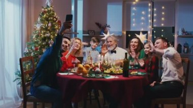 Kafkas ailesi Noel 'i yemek masasında oturarak kutluyor. Güzel, gülümseyen bir aile aile aile yemeği sırasında arkadaşlarıyla veya akrabalarıyla telefon görüşmesi yapıyor..