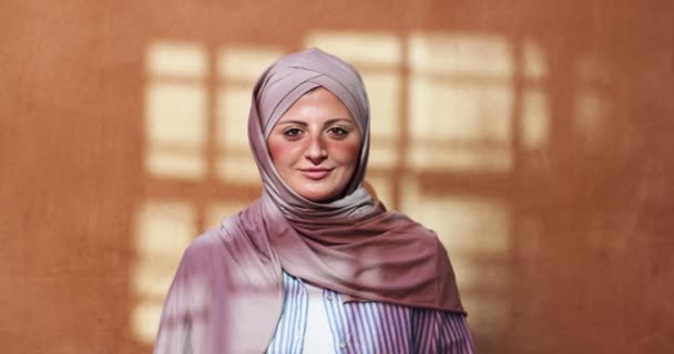 Retrato de mujer árabe bien parecido velo cabeza con bufanda en casa. Joven musulmana usando hijab, de pie y mirando a la cámara en el interior. Religión, feminidad, concepto de libertad. — Vídeo de stock