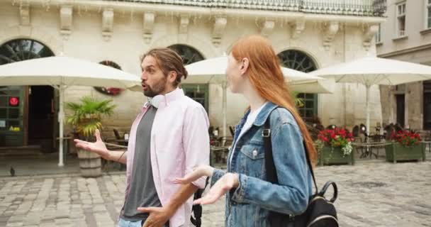 Joven chico y chica caminando por la calle y frente a su amiga. Pareja caucásica hablando y conociendo a una mujer bonita, saludándola y abrazándose en la ciudad. Concepto de amistad, amor y relación. — Vídeos de Stock