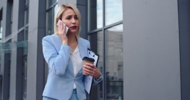 İş hayatında başarılı ve güzel görünümlü genç bayan patron ve telefonda konuşan açık renk saçlı ve dışarıda doküman ve kahveyle dolaşırken bazı kararlar alıyor..