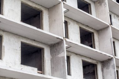 Modern bir binanın ön cephesi yapım aşamasında. Çok katlı bir bina yapım aşamasında. İnşaat konsepti. Yakın görünüm.