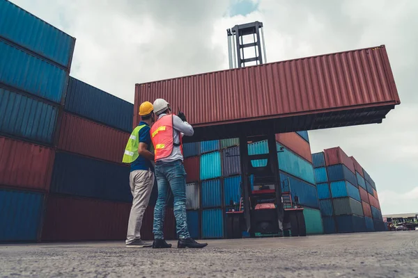 Pracownik przemysłu współpracuje ze współpracownikiem w zagranicznej stoczni kontenerowej — Zdjęcie stockowe