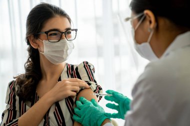 Genç bayan, aşı için yetenekli doktoru hastanede ziyaret ediyor.