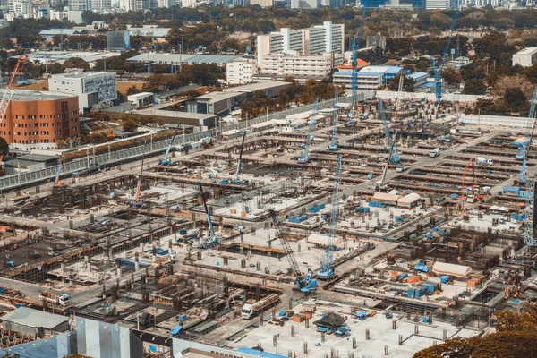 Stor byggeplads med tunge entreprenørmaskiner i metropol - Stock-foto
