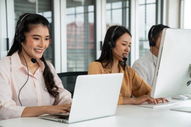 Kulaklık takan iş adamları ofiste aktif olarak çalışıyorlar.