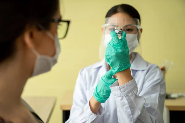 Young woman visits skillful doctor at hospital for vaccination