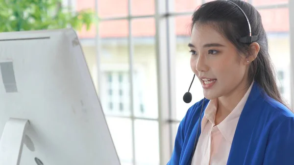 Empresaria con auriculares trabajando activamente en la oficina — Foto de Stock