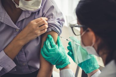 Genç bayan, aşı için yetenekli doktoru hastanede ziyaret ediyor.