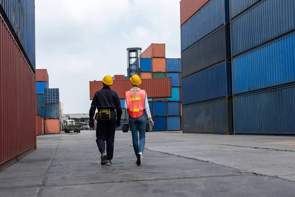 Промышленный рабочий работает с коллегами на зарубежной судоходной контейнерной верфи — стоковое фото