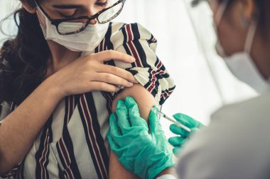 Genç bayan, aşı için yetenekli doktoru hastanede ziyaret ediyor.