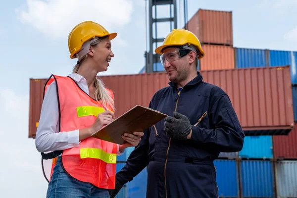 Industrial worker works with co-worker at overseas shipping container yard