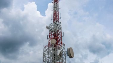 Gökyüzüne ve arkaplandaki bulutlara karşı telekomünikasyon kulesinin zaman atlaması