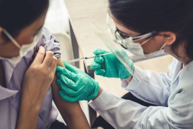 Genç bayan, aşı için yetenekli doktoru hastanede ziyaret ediyor.