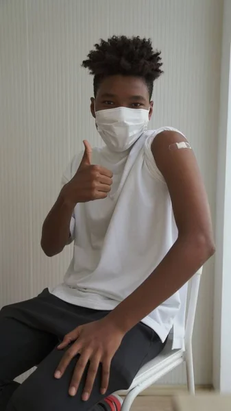 African American teenager showing COVID-19 vaccine bandage merrily — Stock Photo, Image