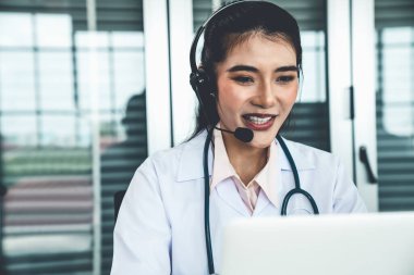 Kulaklık takan doktor hastane ya da klinikteki video konuşmasında aktif olarak konuşuyor.