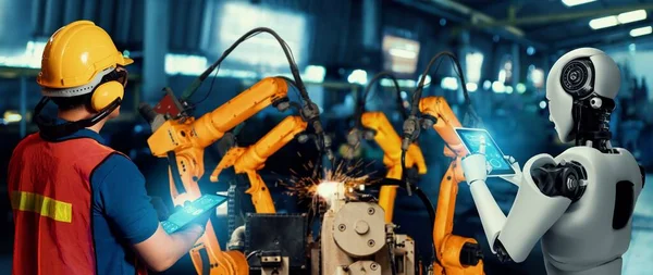 Робот механизированной промышленности и человеческий работник, работающие вместе на будущем заводе — стоковое фото