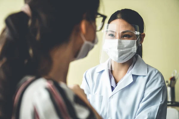 Young woman visits skillful doctor at hospital for vaccination