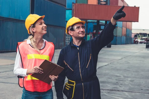 Industriarbetare arbetar med medarbetare på ett varv för containrar utomlands — Stockfoto