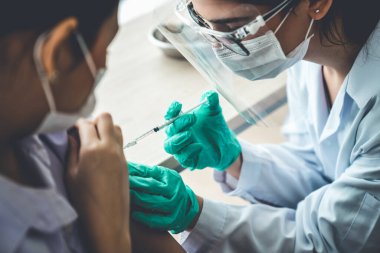Genç bayan, aşı için yetenekli doktoru hastanede ziyaret ediyor.