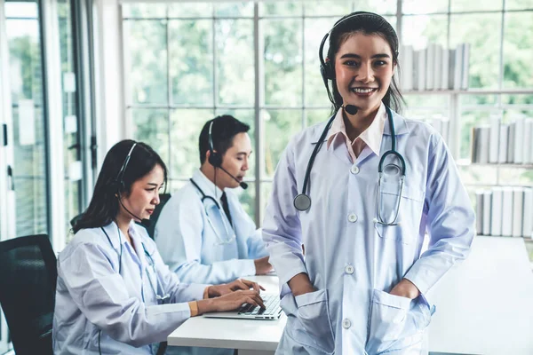 Läkare team bär headset talar aktivt på videosamtal på sjukhus klinik — Stockfoto