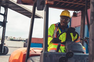 Tersanede forklift kullanan Afrikalı Amerikalı bir adam.