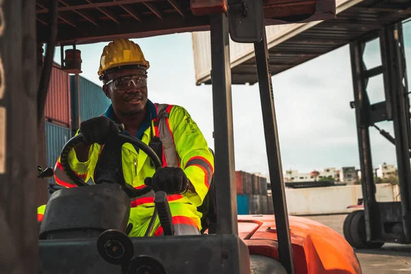 African american man driving forklift in shipyard