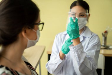 Genç bayan, aşı için yetenekli doktoru hastanede ziyaret ediyor.
