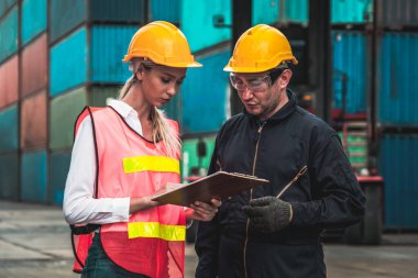 Endüstriyel işçiler, deniz aşırı nakliye konteynır sahasında iş arkadaşlarıyla çalışıyor.
