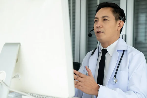 Doctor wearing headset talking actively on video call in a clinic or hospital . — Stock Photo, Image