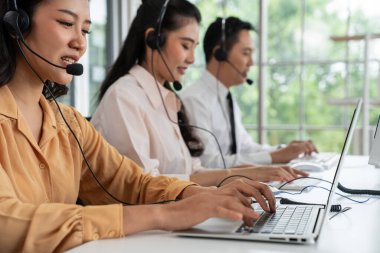 Kulaklık takan iş adamları ofiste aktif olarak çalışıyorlar.