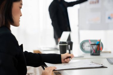 İş kadını toplantı yapıyor. Ofis odasında kağıt yazıyor. .