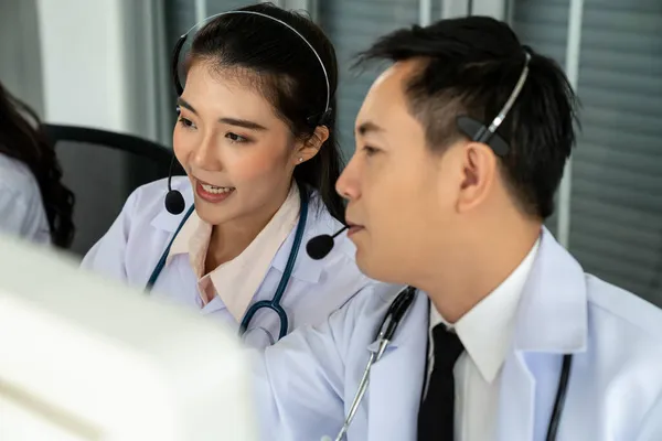 Team di medici con auricolari che parlano attivamente in videochiamata in clinica ospedaliera — Foto Stock