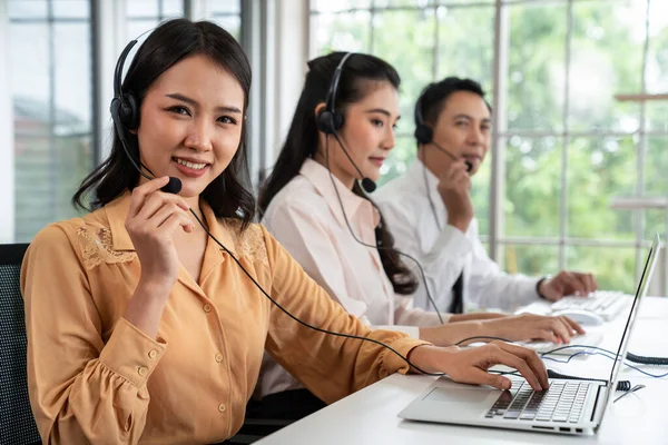 Kulaklık takan iş adamları ofiste aktif olarak çalışıyorlar.